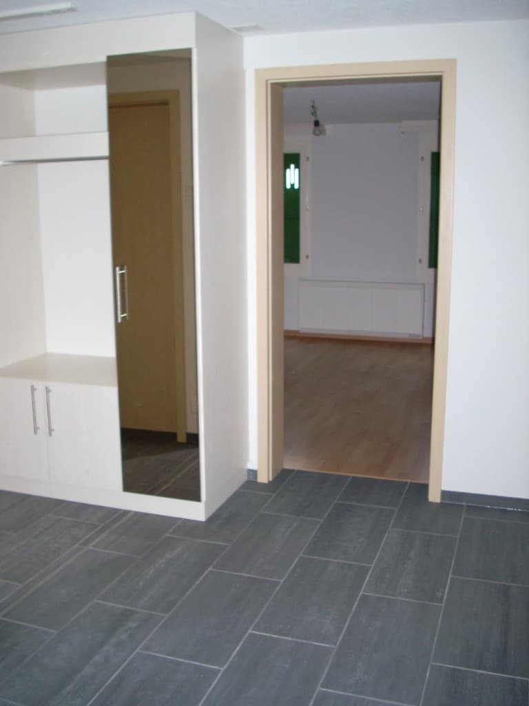 Erstes Obergeschoss mit Plattenboden und Einbauschrank, Blick in einen Raum mit Parkett